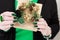 Female hands with green manicure hold a gift box for New Year