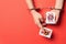 Female hands in handcuffs holding playing cards on color background