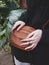 Female hands with handmade rings and a small leather bag on a background of tropical leaves, Blogger style, Atmospheric, Selective