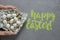 Female hands hold chicken and quail eggs in a plate with a towel on a gray concrete background. Top view. Flat lay