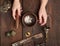 Female hands hold a copper Tibetan singing bowl and a wooden stick