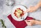 Female hands hold Italian pasta Conchiglioni Rigati stuffed with cheese and greens on concrete table