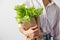 Female hands hold a packet with lettuce on a gray background. Organic food