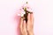 Female hands hold rose flowers on a pink pastel background. Beauty and care