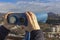 Female hands hold sightseeing touristic telescope. View from the observation deck viewing platform at the mountains lan