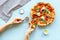 Female hands hold slice of pizza. Overhead view