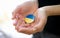 Female hands holding badge with flag of Ukraine closeup