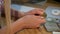 Female hands holding bitcoin. Crop view of hands of woman holding shiny metal bitcoin sitting at wooden desk with wad of