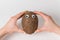 Female hands holding brown coconut on white background. coconut with Googly eyes