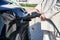 Female hands holding charger for electric car.