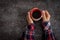 Female hands holding coffee cup over dark table