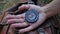 Female hands holding compass and looking for direction of North. Orientation in forest