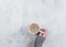 Female hands holding cups of coffee on white marble table background. Copy space, topview, flat lay