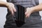 Female hands holding empty black purse, grey background