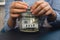 Female hands holding Glass jar full of American currency dollars cash banknote with text 2025 year. Preparation saving