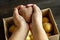 Female hands holding a heart-shaped ugly vegetable potato over a box filled with potatoes. square  ugly food