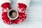 Female hands holding hot coffee above wooden table