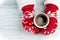 Female hands holding hot coffee above wooden table