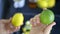 Female hands holding a lemon and a lime above fruit slices