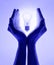 Female hands and holding luminous light bulb. Electric incandescent light bulb in hand on purple background. Inspiration