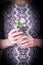 Female hands holding pink carnation flowers in black waffle cone on a black and white dress. Snake skin texture