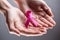 Female hands holding pink ribbon, breast cancer concept