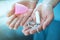 Female hands holding pink silicone menstrual cup and cotton tampon for critical days