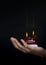 Female hands holding a red double flamed flat candle