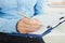 Female hands holding a silver pen closeup. Business woman making notes at office workplace.