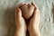 Female hands holding ugly vegetables potatoes in the shape of a heart on a background of linen cloth. square  ugly food