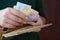 Female hands holding ukrainian hryvnia bills in small money pouch or wallet