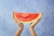 Female hands holding watermelon slice on light background