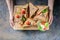 Female hands holding a wooden board with fresh beef sandwiches, tomatoes and green salad. Traditional breakfast, lunch or snack.