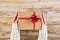 Female hands holfing festive gift box against wooden background