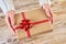 Female hands holfing festive gift box against wooden background