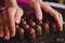 Female hands with homemade chocolate pralines on a marble surface for tempering melted chocolate mass. Closeup