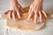 Female hands housewife with wedding ring roll out dough wooden rolling pin on white table background