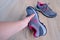 Female hands inspecting a pair of gray new womens trekking shoes with pink trim, tied with laces, concept of comfortable sports