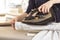 Female hands iron the shirt sleeve on a stand on an ironing board. Ironed clothes lie on the table in the background.