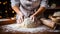 Female hands knead the dough on a wooden table in the kitchen