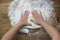 Female hands knead the dough on a wooden table, sprinkled with flour, close-up, selective focus, home cooking concept, copy space