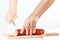 Female hands with a knife sliced salami on a cutting board