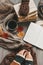 Female hands knitting sweater on the floor with autumn leaves and cup of coffee