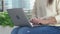 Female hands on laptop, woman types on keyboard sitting in park. Working outside and freelance concept.