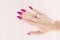 Female hands with long nails with light pink nail polish