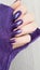 Female hands with long nails with purple nail polish