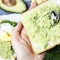 Female hands making avocado sandwich, top view