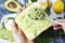 Female hands making avocado sandwich, top view