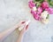 Female hands manicure cream cosmetic purity flower peony on concrete background