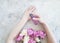 Female hands manicure cream hygiene cosmetic purity flower peony on concrete background